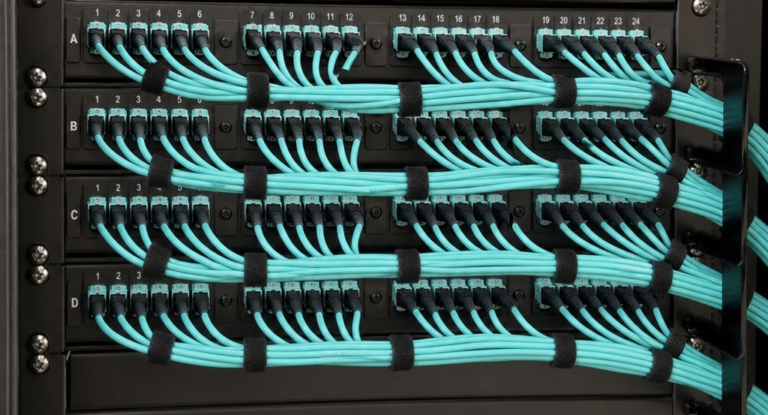 High-density MPO/MTP patch panel in a server rack with aqua OM4 multimode fiber patch cables